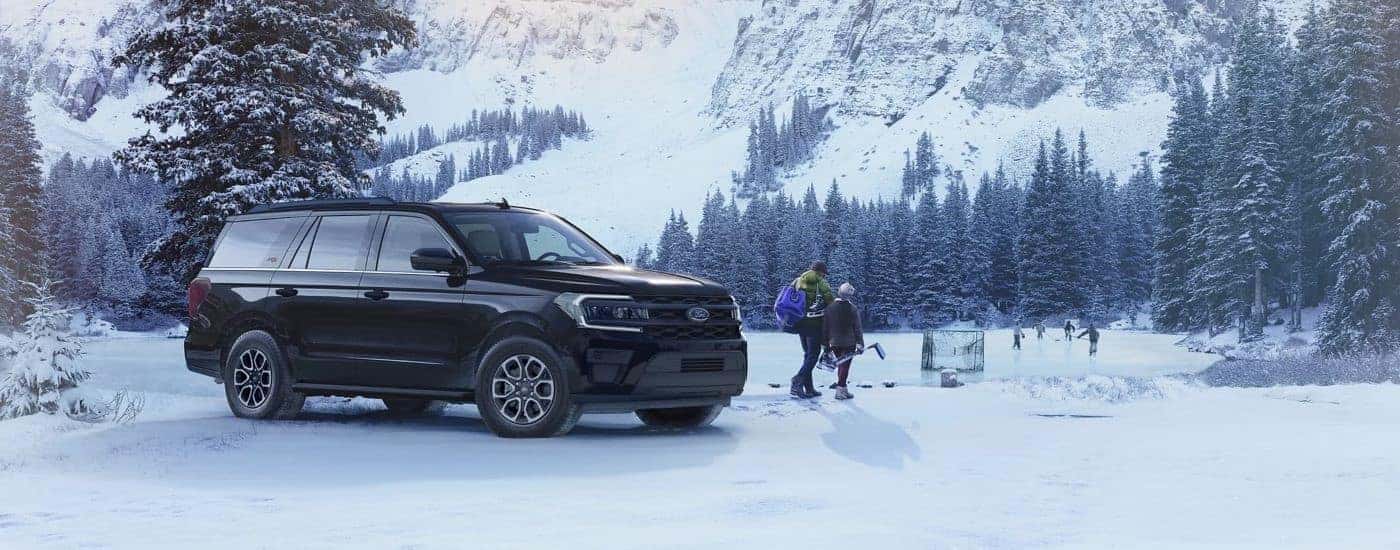 A black 2023 Ford Expedition XL STX parked off-road in the snow.