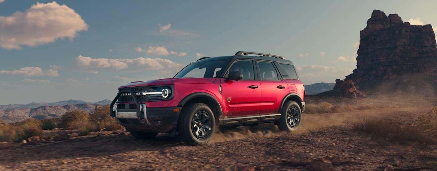 A red 2025 Ford Bronco Sport Sasquatch Badlands driving off-road.