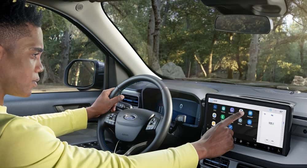 A man using the touch screen infotainment display in a 2025 Ford Maverick