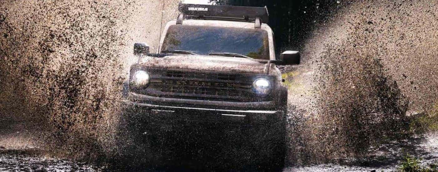 A 2022 Ford Bronco off-roading in mud.