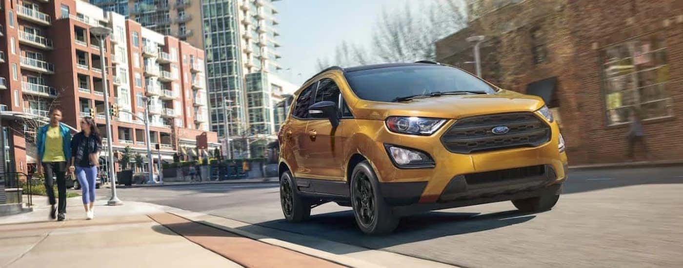 A gold 2022 Ford EcoSport driving on a city street.