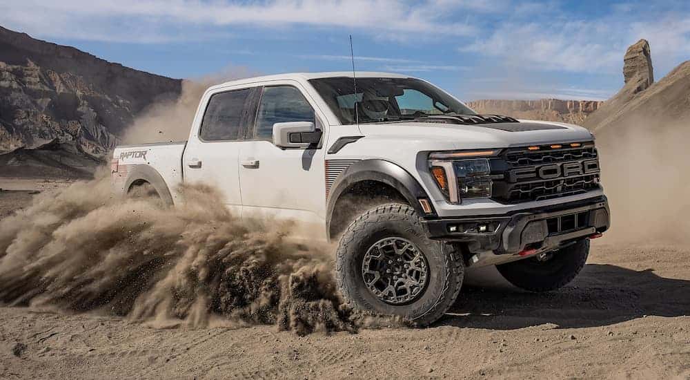 A white Ford F-150 off-roading on sand