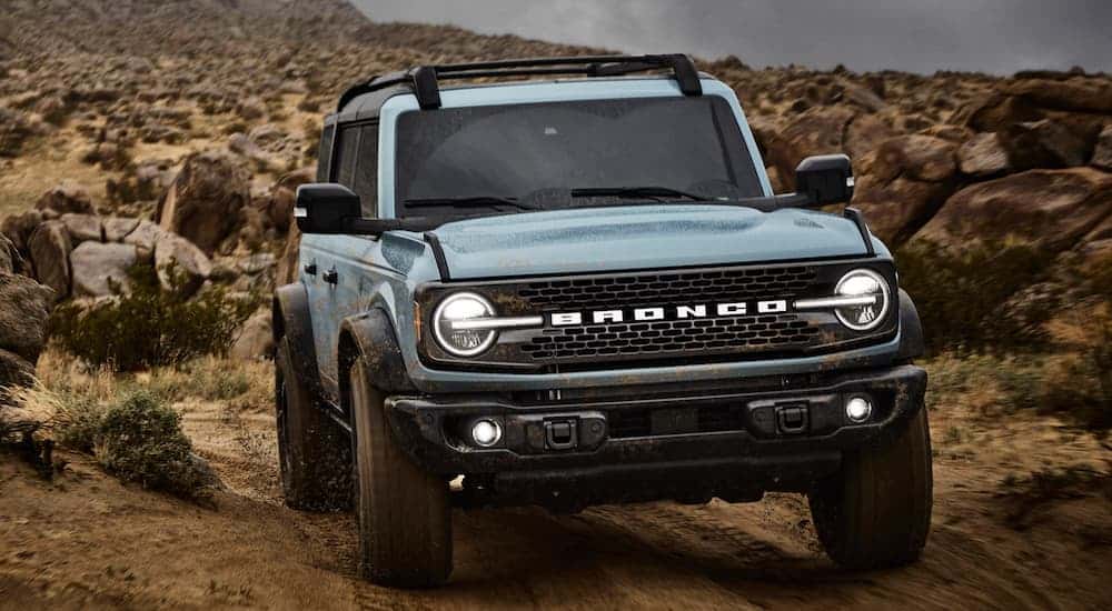 A blue 2025 Ford Bronco off-roading on a trail