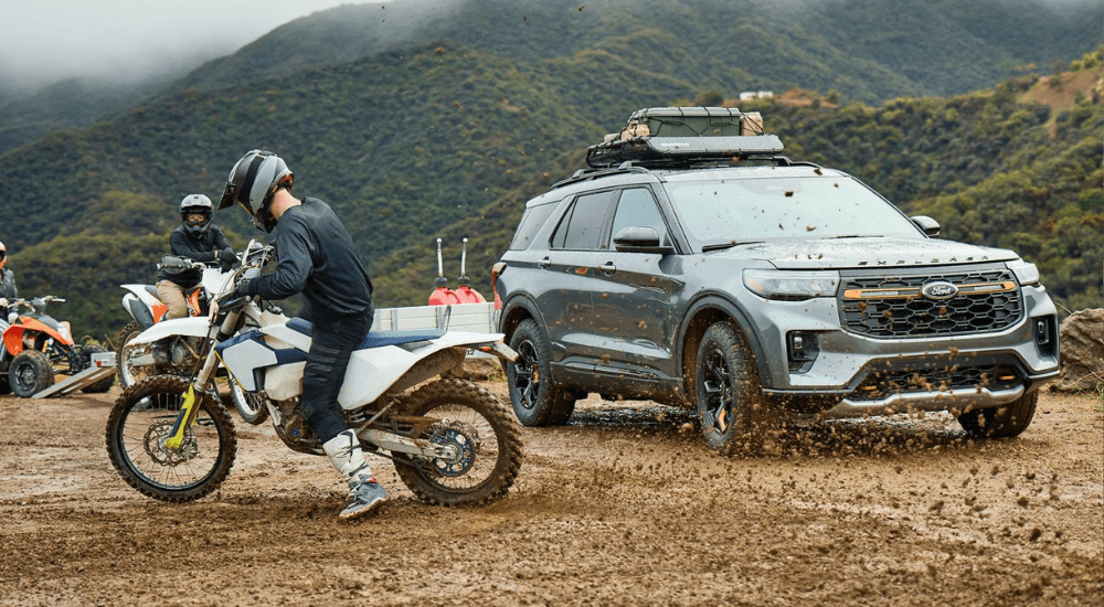 A person sits on a dirt bike in front of a silver 2026 Ford Explorer Tremor after leaving a Ford dealer near Crawfordsville.