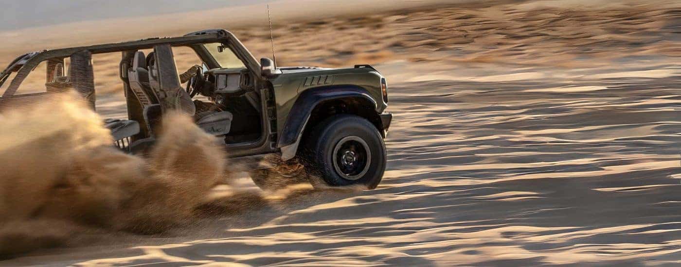 Green 2024 Ford Bronco Raptor driving off-road