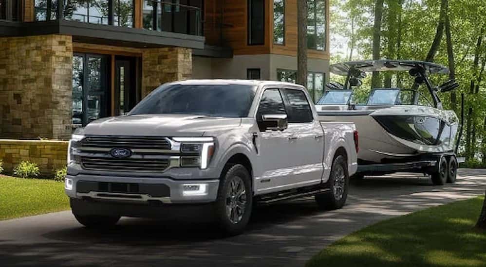 A white 2026 Ford F-150 towing a boat.