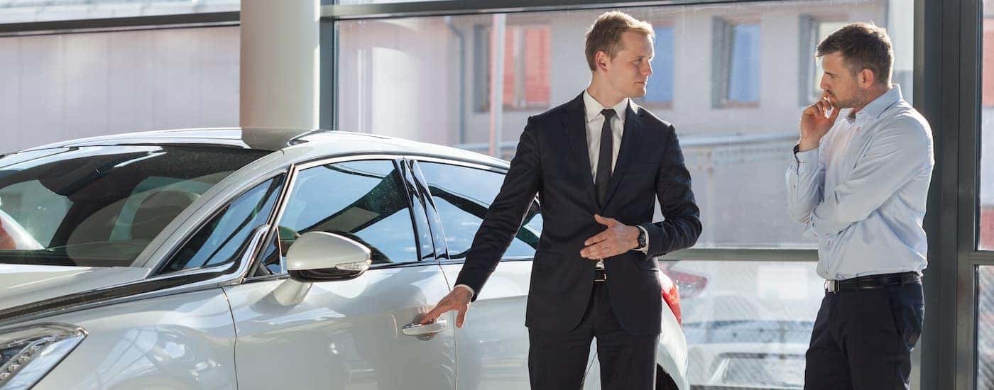 A salesman is shown speaking to customers about used cars for sale near you.