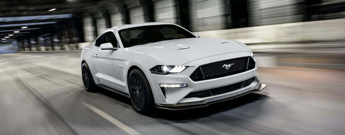 A white 2020 Ford Mustang GT is shown driving through a tunnel after visiting a Ford dealer near you.