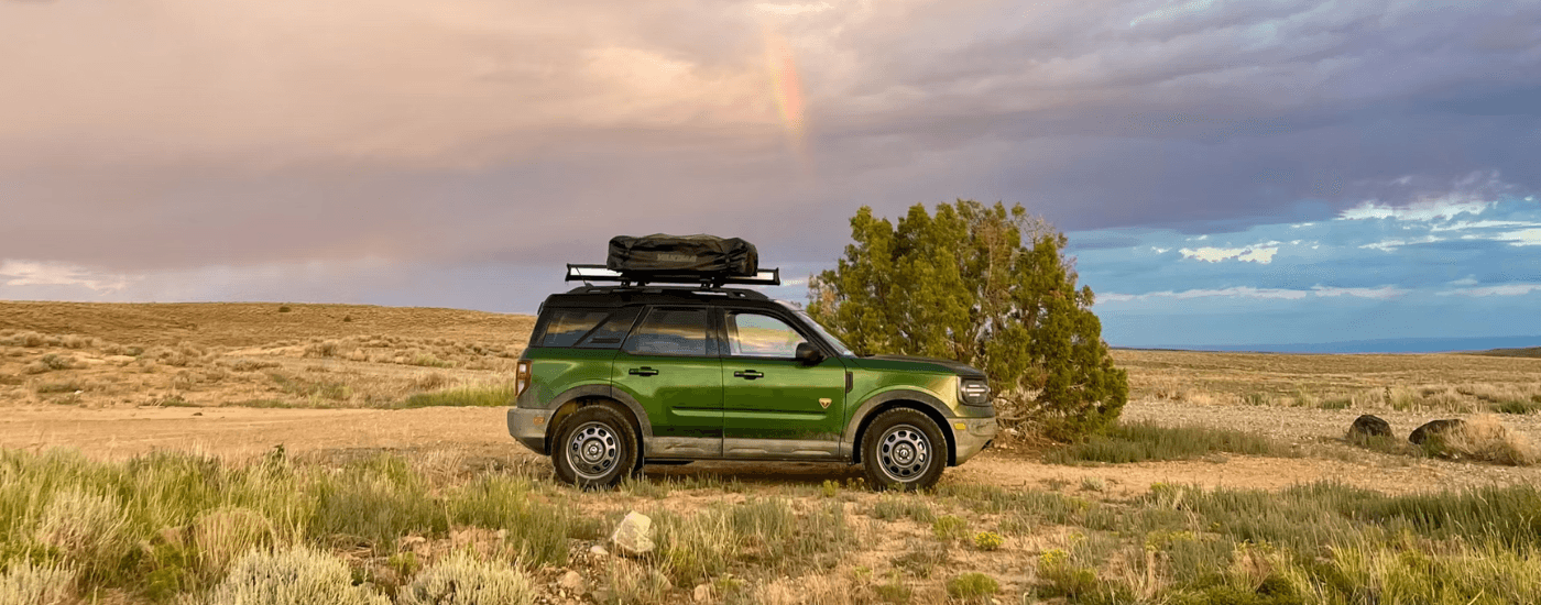 Green 2025 Ford Bronco Sport from the side driving off-road.
