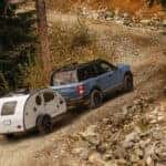 Blue 2026 Ford Bronco Sport towing a small camper trailer