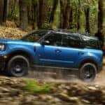 Blue 2026 Ford Bronco Sport Badlands off-roading on a dirt trail