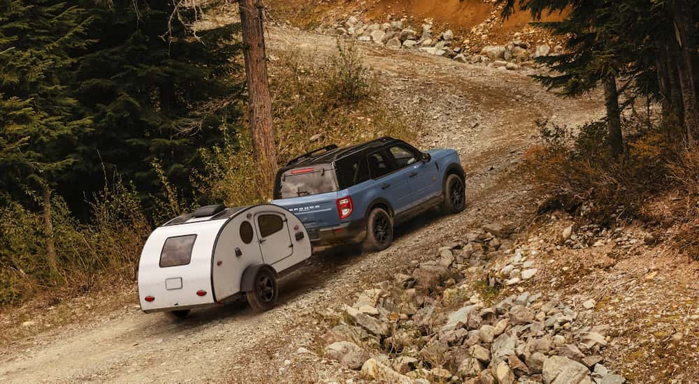 Blue 2026 Ford Bronco Sport towing a small camper trailer