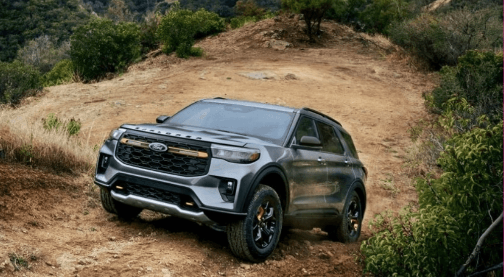 Silver 2026 Ford Explorer tremor driving up a trail