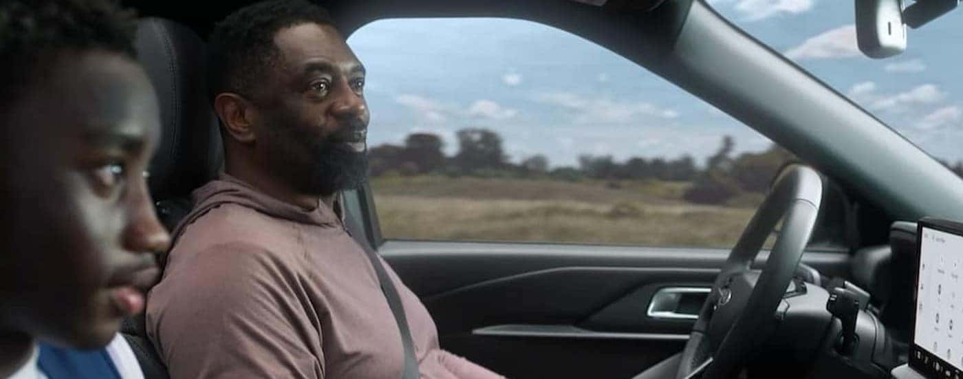 Two people driving in a 2026 Ford Explorer.