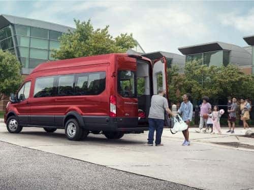 2024 Ford Transit parked outside a building with a line of people walking to load into van