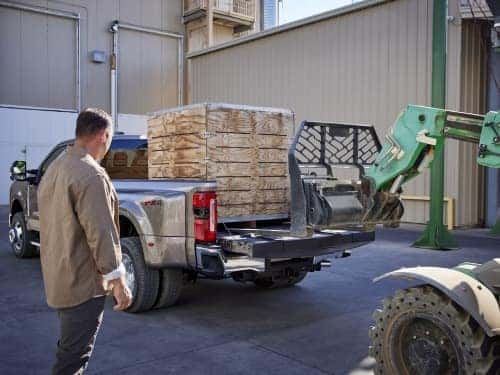2025 Ford Super Duty view of tractor loading wood pallets into back of truck