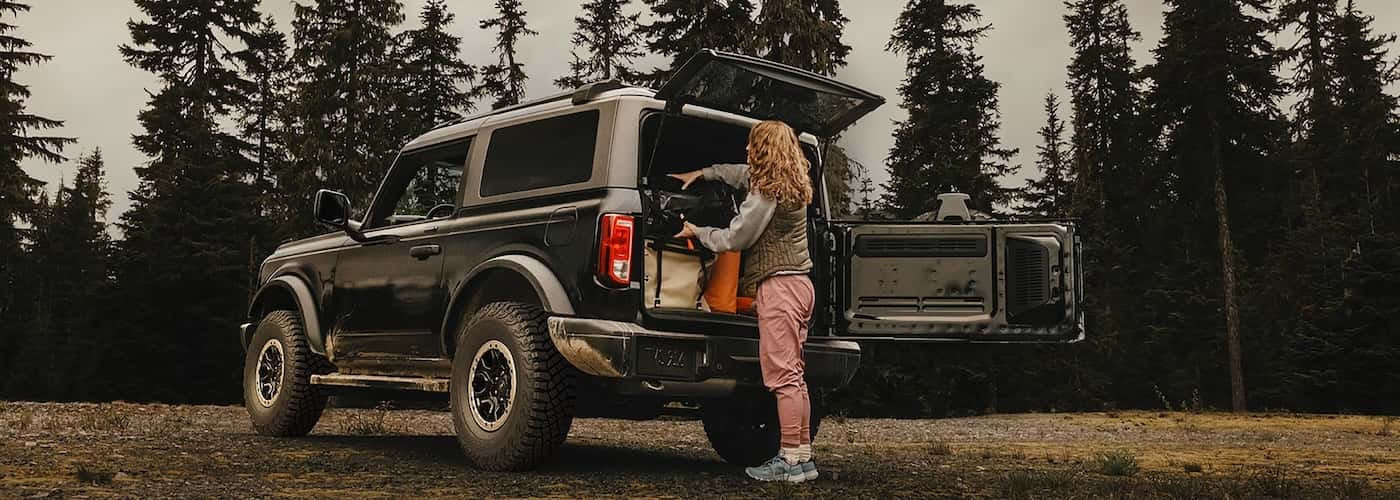 Woman loading cargo into the back of a Bronco