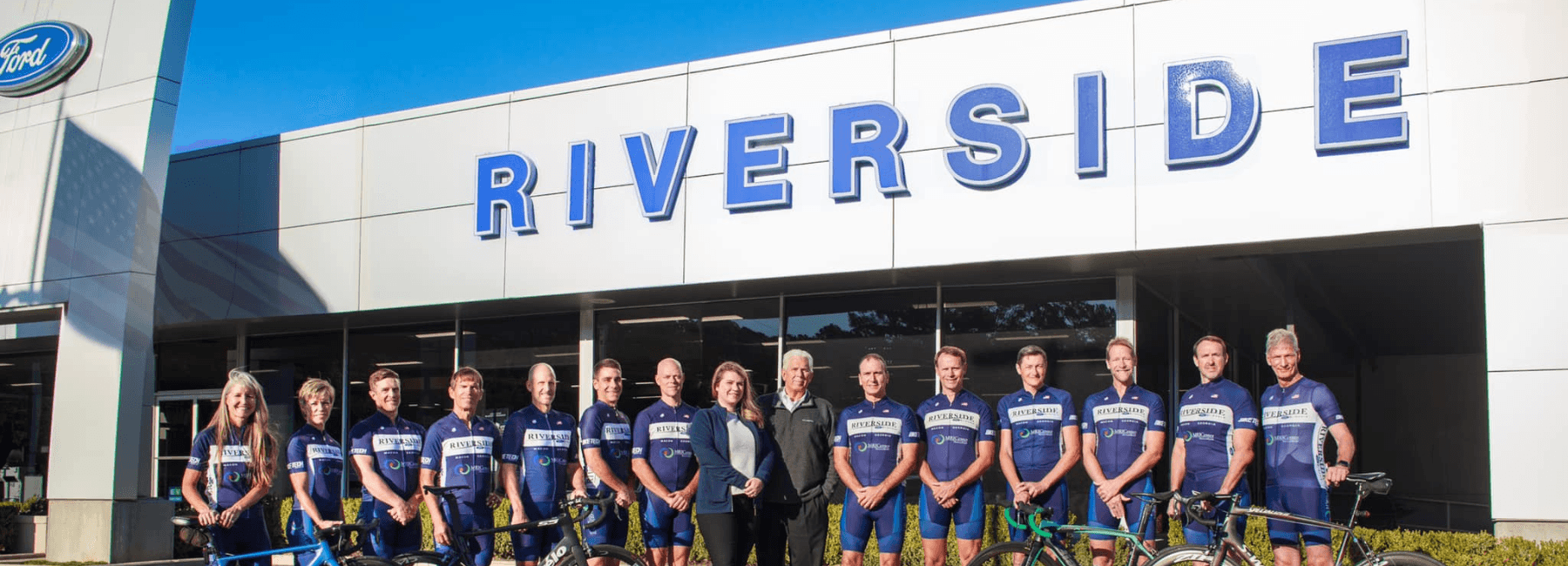 Image of dealership staff out front of store while sitting on their bikes