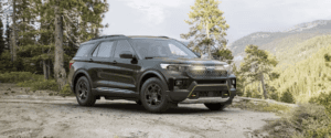 2024 Ford Explorer in black paint parked on gravel in a forest.