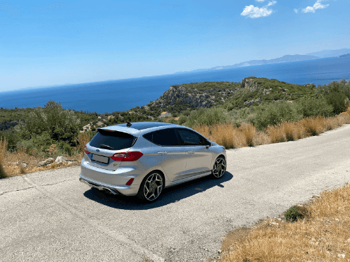 Silver Ford vehicle parked alongside a scenic background.