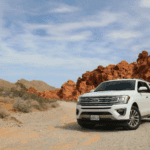 White Ford Explorer parked in a desert environment.