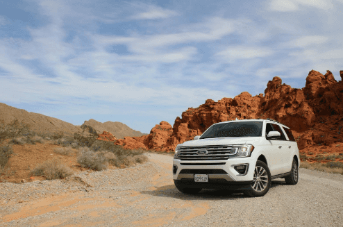 White Ford Explorer parked in a desert environment.