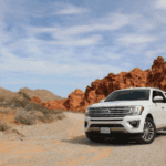 Ford Expedition driving a winding road in the fall season.