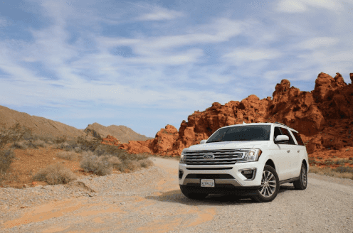 Ford Expedition driving a winding road in the fall season.
