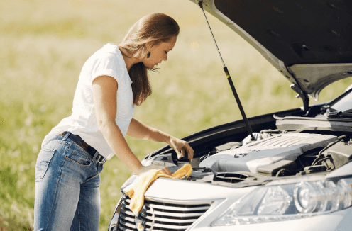 Woman performing road side maintenance on her vehicle.