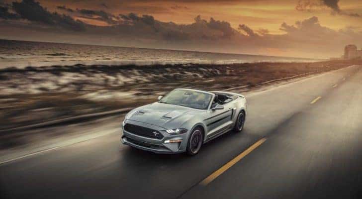 A silver 2020 Ford Mustang California Special is shown on a coastal road after after leaving a Ford dealer near you.