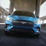A blue 2023 Ford Mustang Mach-E is shown from the front after leaving a Ford dealer in San Leandro.