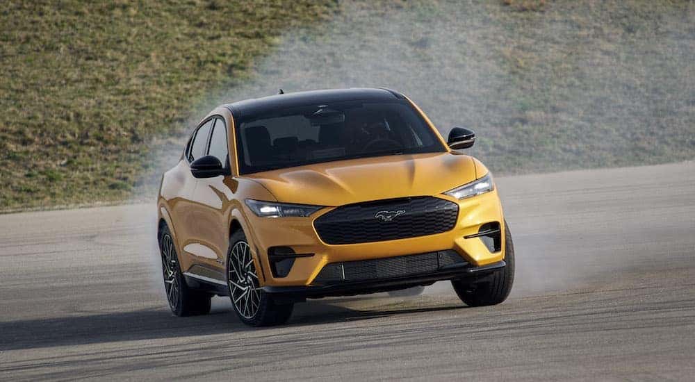 A yellow 2024 Ford Mustang Mach-E is shown from the front while sliding.