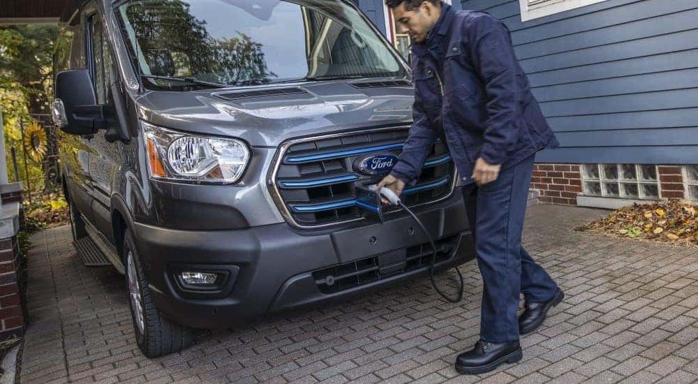 A grey 2023 Ford E-Transit is shown being charged.