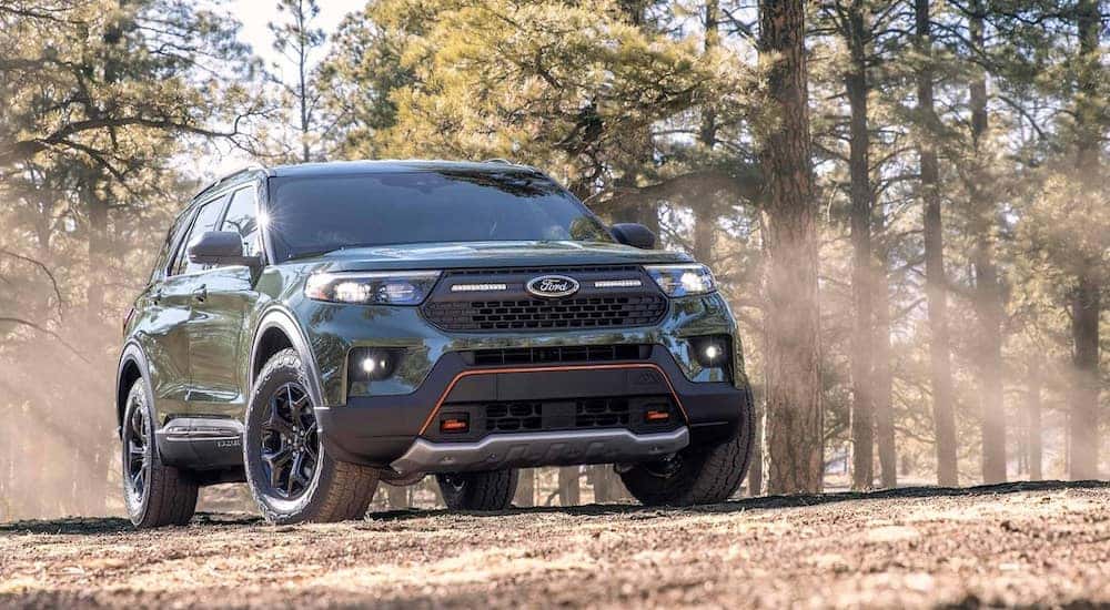 A green 2024 Ford Explorer Timberline driving through a forest.