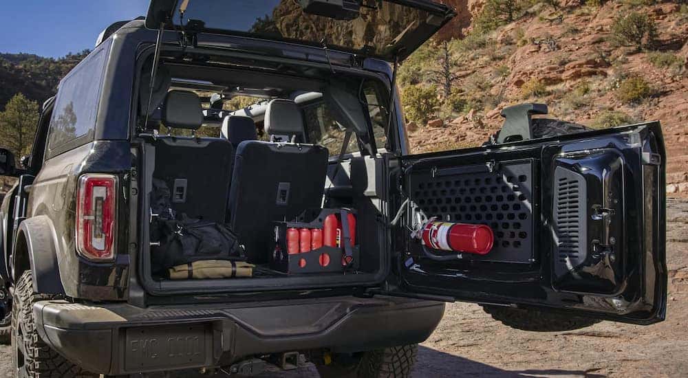 The open tailgate of a 2023 Ford Bronco with off-roading gear in the trunk.