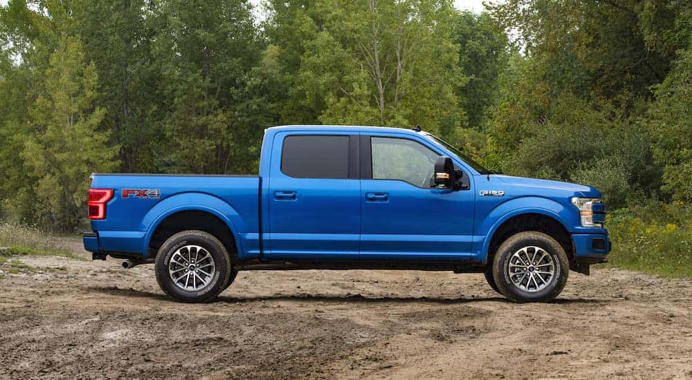 A blue 2019 Ford F-150 FX4 is parked on a dirt lot.