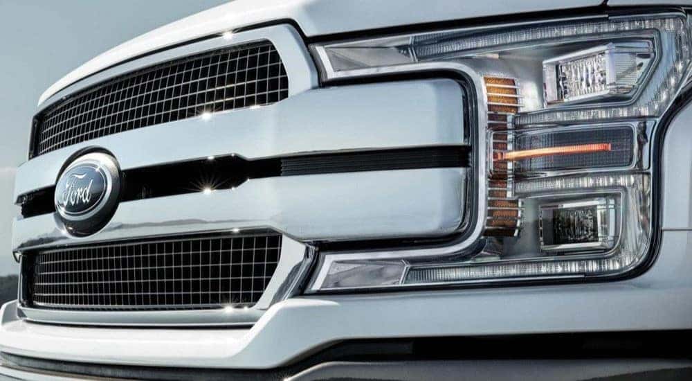 A close up of the headlight on a silver 2020 Ford F-150 used truck for sale.