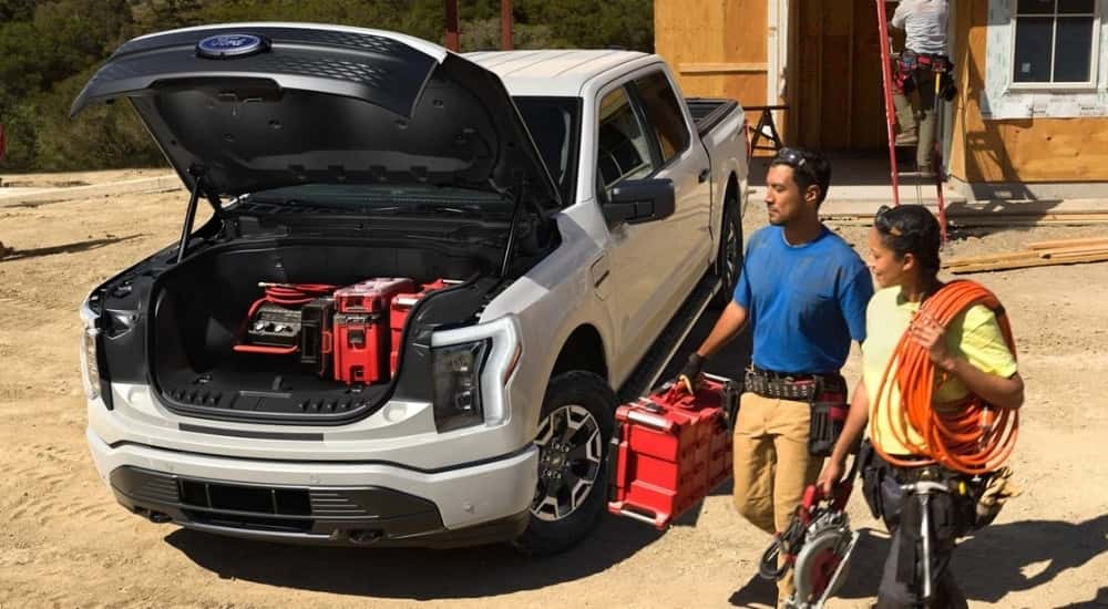 A white 2022 Ford F-150 Lightning Pro on a construction site.