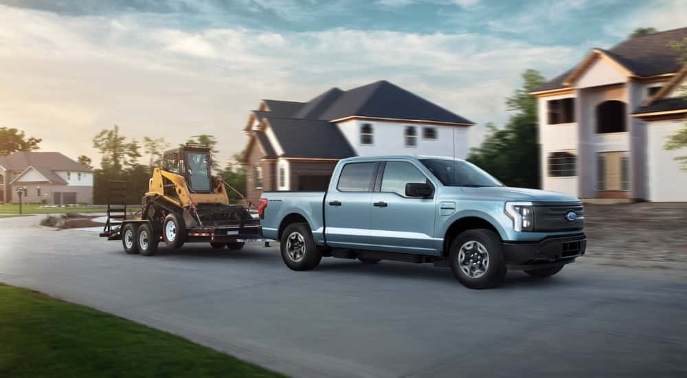 A blue 2022 Ford F-150 Lightning for sale near Oakland towing construction equipment