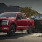 Red 2025 Ford F-150 STX towing a boat out of a lake after visiting a Ford dealer near Livermore.