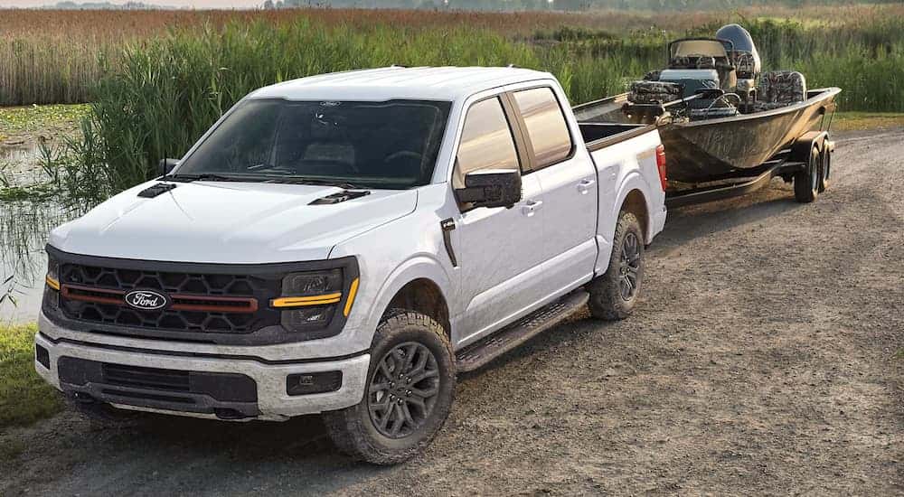 A white 2025 Ford F-150 for sale towing a boat