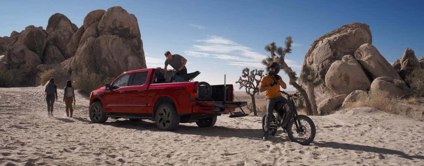 A red 2025 Ford F-150 Lightning parked off-road.