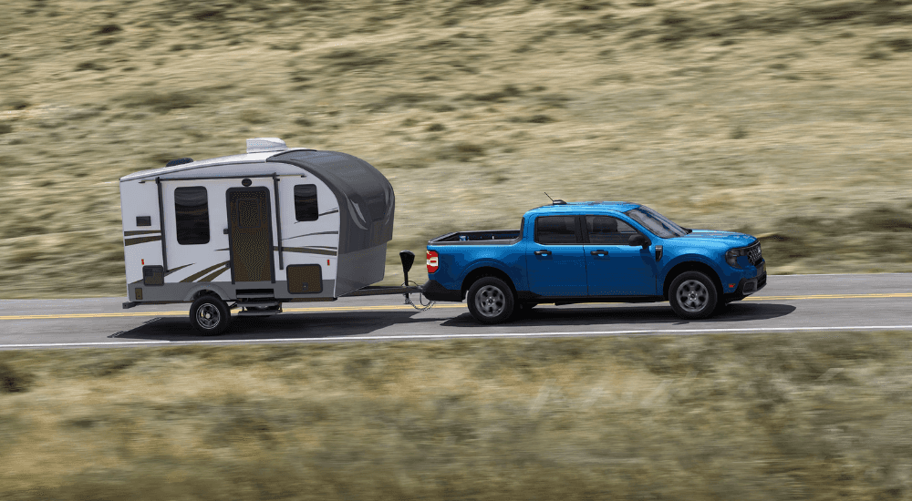 Blue 2026 Ford Maverick towing a camper