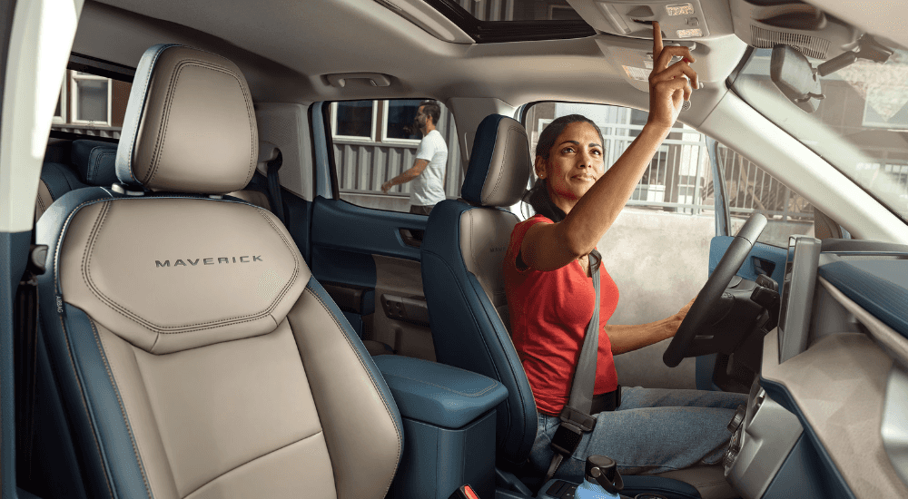 A person using the ceiling controls in a 2026 Ford Maverick for sale in Hayward