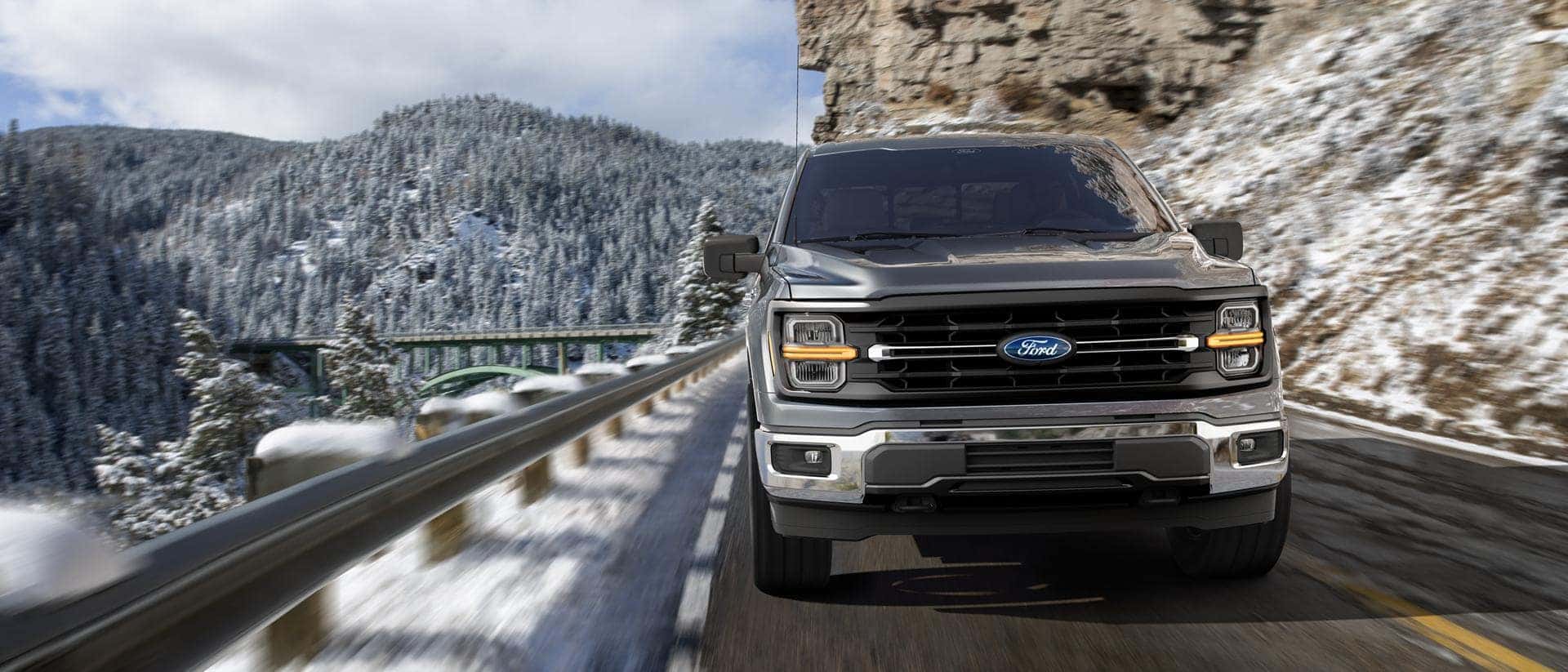 Silver 2026 Ford F-150 driving up a hill