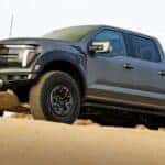 Grey 2026 Ford F-150 Raptor driving through sand