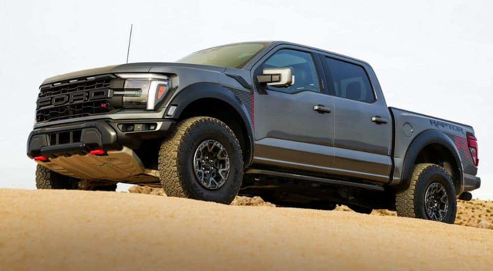 Grey 2026 Ford F-150 Raptor driving through sand