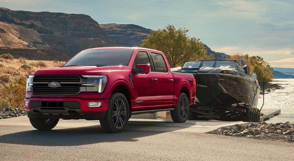 Red 2026 Ford F-150 STX FX4 towing a boat out of the water