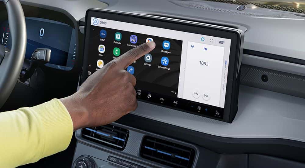 A person using the 13.2 inch infotainment screen on a Ford Maverick XLT.