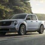 Grey 2026 Ford Maverick XLT driving on a windy road.